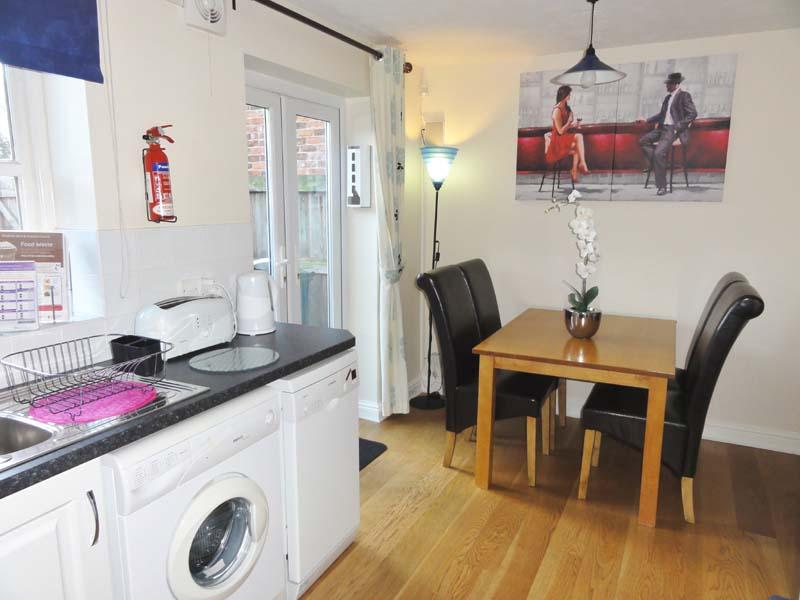 Fully equipped kitchen with Juliet doors leading to cottage patio. Lever tap handles.